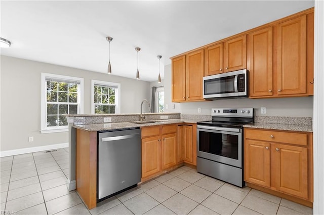 kitchen featuring pendant lighting, kitchen peninsula, sink, and stainless steel appliances