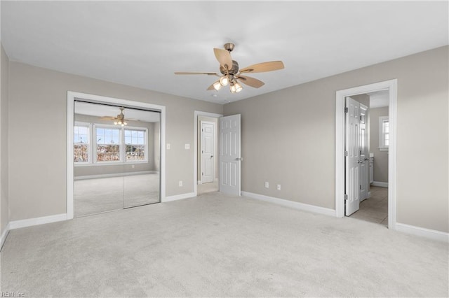 unfurnished bedroom featuring ensuite bathroom, ceiling fan, a closet, and light colored carpet