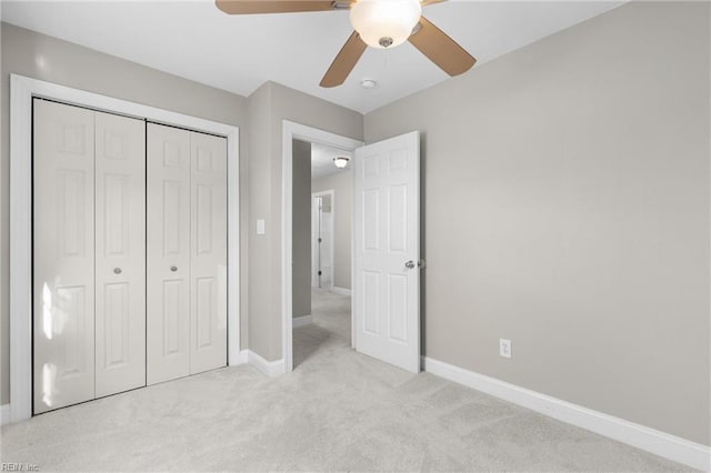 unfurnished bedroom with light carpet, ceiling fan, and a closet