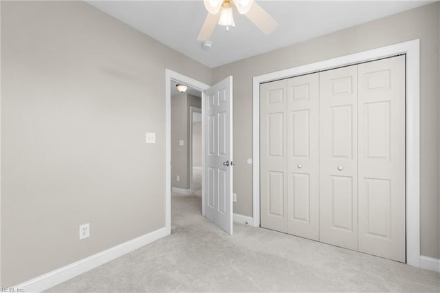 unfurnished bedroom with a closet, light colored carpet, and ceiling fan