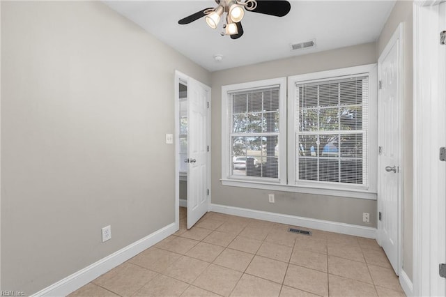 empty room with light tile patterned flooring and ceiling fan