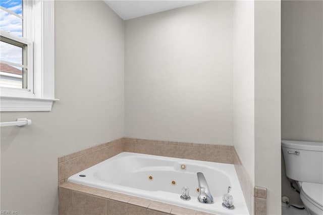 bathroom with tiled tub and toilet