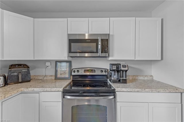 kitchen featuring white cabinetry, light stone countertops, and stainless steel appliances