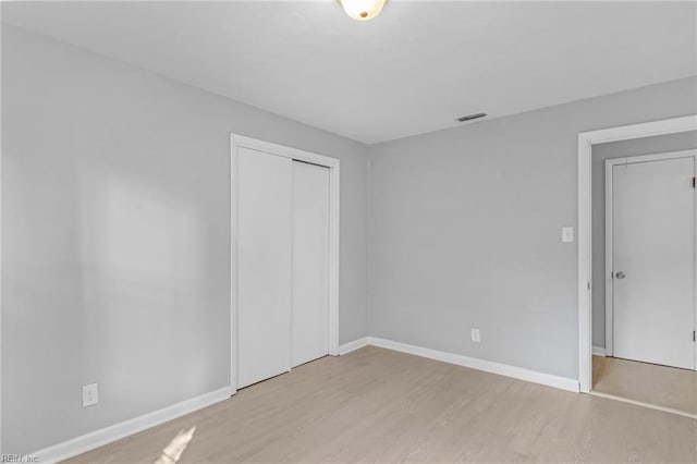 unfurnished bedroom featuring a closet and light hardwood / wood-style floors