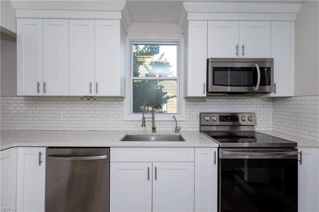 kitchen featuring white cabinets, a wealth of natural light, sink, and appliances with stainless steel finishes