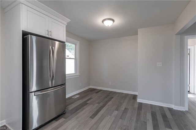 kitchen with white cabinets, dark hardwood / wood-style flooring, and stainless steel fridge