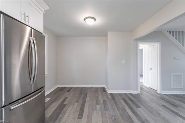 kitchen featuring white cabinetry, hardwood / wood-style floors, and stainless steel refrigerator