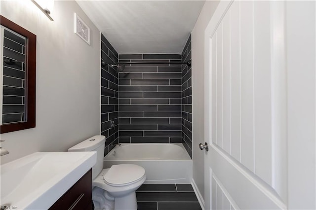 full bathroom featuring vanity, tile patterned flooring, tiled shower / bath, and toilet