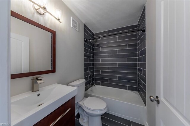 full bathroom with vanity, tile patterned floors, tiled shower / bath, and toilet