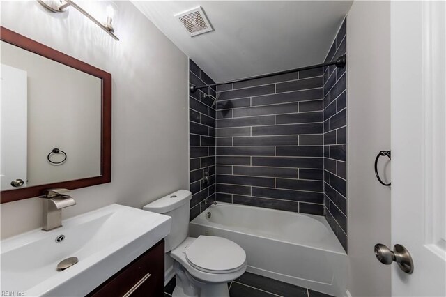 full bathroom with tile patterned flooring, tiled shower / bath, toilet, and vanity