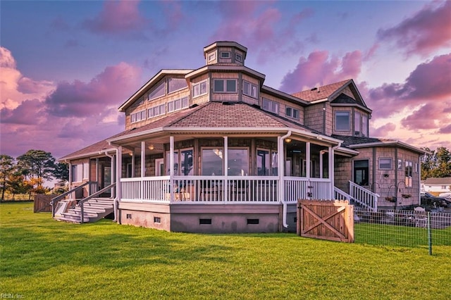 view of front facade with a lawn and a sunroom