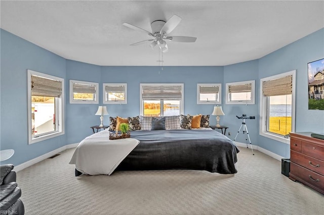 carpeted bedroom featuring ceiling fan and multiple windows