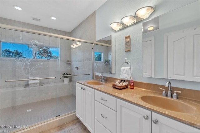 bathroom with an enclosed shower, vanity, and tile patterned flooring