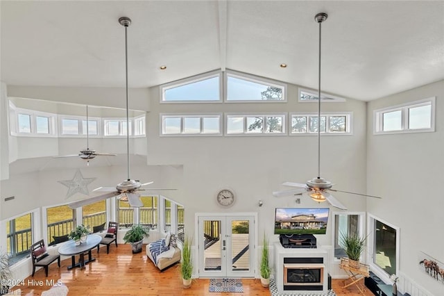 living room featuring french doors, wood-type flooring, and high vaulted ceiling