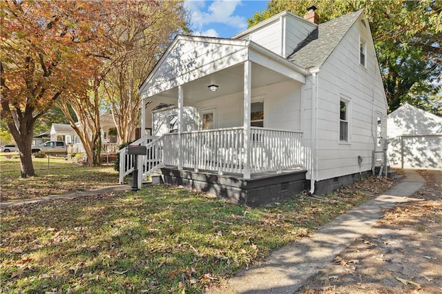 view of front of house featuring an outbuilding, a garage, and covered porch