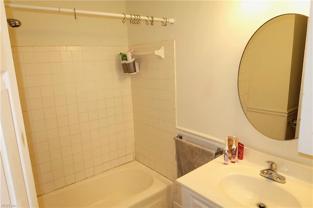 bathroom featuring vanity and tiled shower / bath