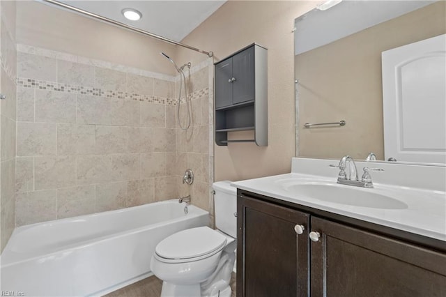 full bathroom with toilet, vanity, and tiled shower / bath