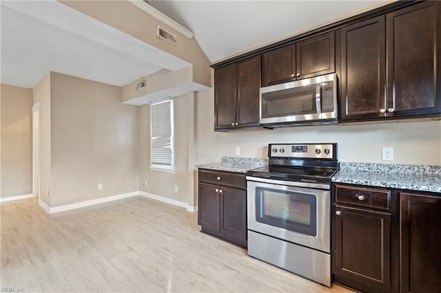 kitchen featuring stainless steel appliances, light stone countertops, and dark brown cabinetry