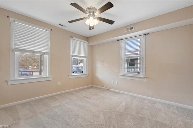 spare room featuring light colored carpet and ceiling fan