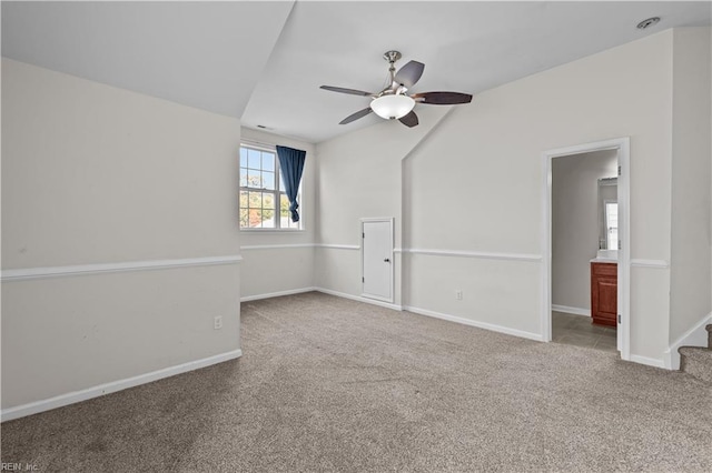 spare room featuring vaulted ceiling, light colored carpet, and ceiling fan