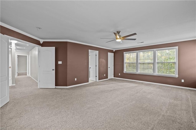 unfurnished bedroom with decorative columns, ceiling fan, crown molding, and carpet