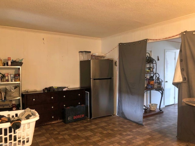 kitchen featuring stainless steel fridge, dark brown cabinets, crown molding, and a textured ceiling