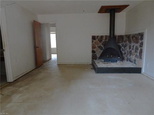 unfurnished living room with a wood stove