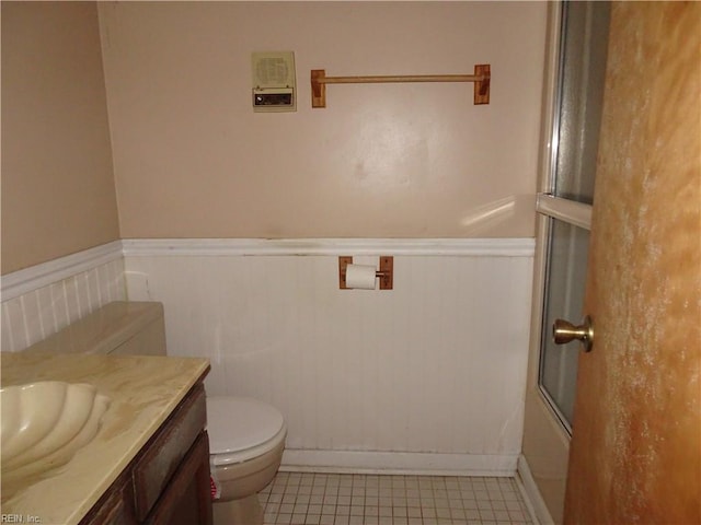 full bathroom featuring tile patterned flooring, shower / bath combination with glass door, vanity, and toilet