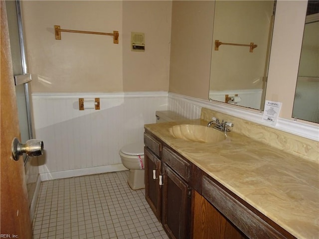 bathroom featuring vanity, tile patterned floors, and toilet