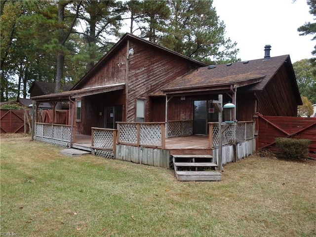 back of property featuring a deck and a lawn