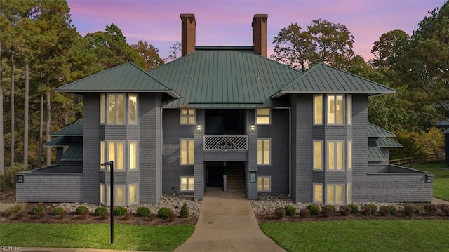 view of front of property with a balcony and a yard