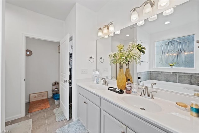 bathroom featuring tile patterned flooring, vanity, and a washtub