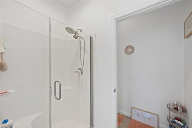 bathroom with a shower with door and tile patterned flooring