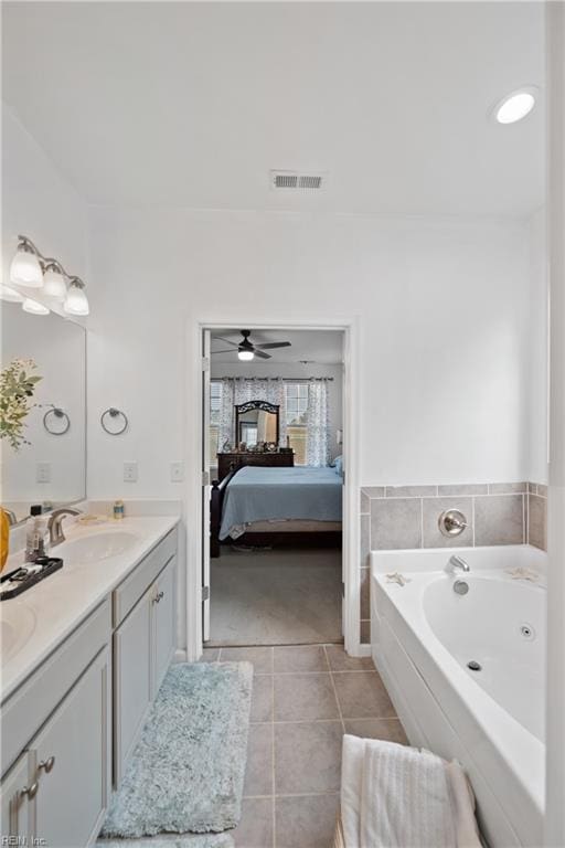 bathroom with tile patterned flooring, vanity, ceiling fan, and a bathing tub