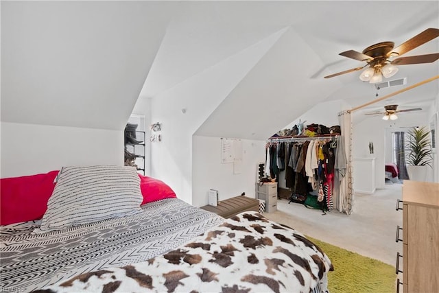 bedroom with ceiling fan, a closet, light carpet, and vaulted ceiling