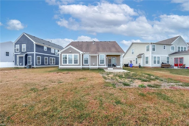 back of property with cooling unit and a yard