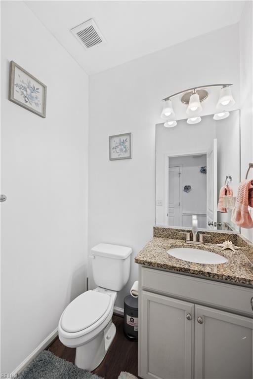 bathroom featuring vanity, wood-type flooring, and toilet