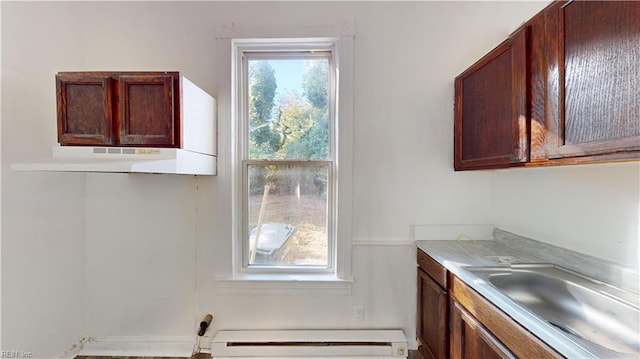 kitchen featuring baseboard heating, sink, and range hood