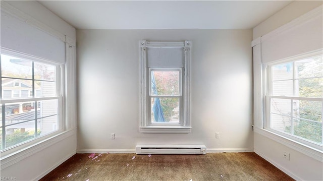 unfurnished room featuring a baseboard heating unit, carpet flooring, and a healthy amount of sunlight