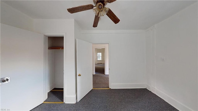 unfurnished bedroom with a closet, dark carpet, and ceiling fan