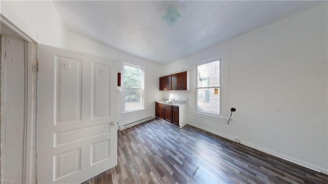 interior space featuring lofted ceiling, dark hardwood / wood-style floors, and a baseboard heating unit