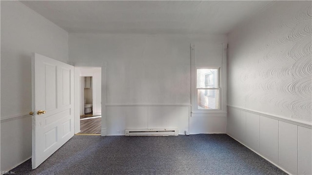 carpeted spare room featuring a baseboard heating unit