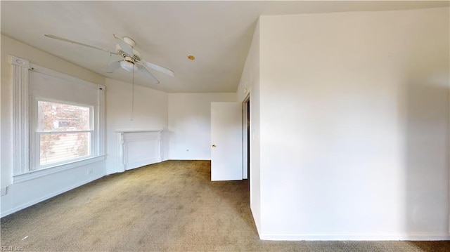 empty room featuring ceiling fan and light carpet