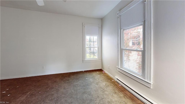 carpeted spare room with a baseboard heating unit