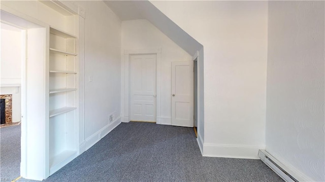 bonus room featuring a baseboard heating unit and dark carpet