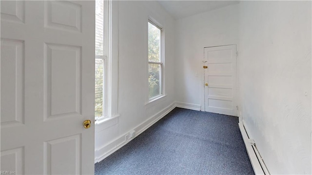 entrance foyer with baseboard heating and dark colored carpet