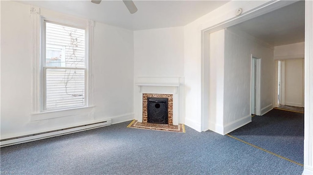 unfurnished living room with a fireplace, ceiling fan, dark carpet, and a baseboard heating unit