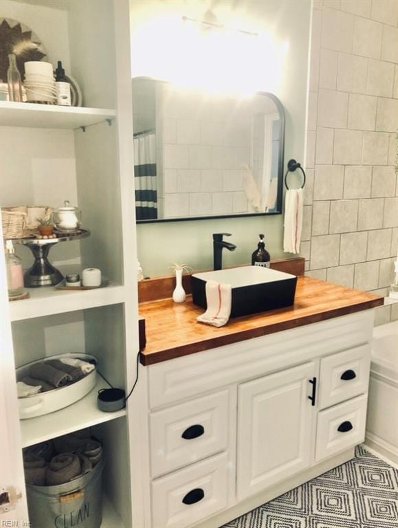 bathroom featuring curtained shower, vanity, and tile patterned floors