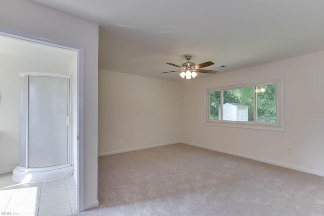 unfurnished room with ceiling fan and light carpet