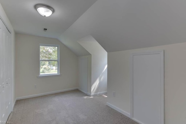 bonus room featuring lofted ceiling and light carpet